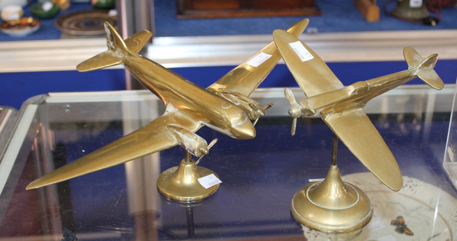 A brass desk top model of a Spitfire on stand and a brass Dakota on stand. Best Bid