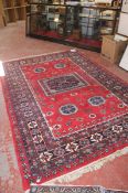 A Middle Eastern rug with central square medallion on red ground approx. 320 x 216cm