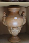 A large terracotta vase with twin mask details; 53cm high