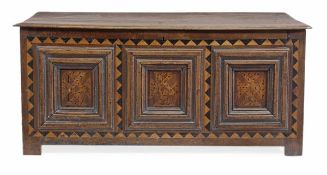 A Charles II panelled oak chest, circa 1660, the hinged lid above a triple panelled front, within