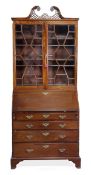 A George III mahogany bureau bookcase, circa 1790, with a priced scrolling pediment, above pair of