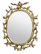 A George III carved giltwood oval wall mirror, circa 1770, the oval plate within a moulded frame
