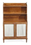 A Regency simulated rosewood waterfall bookcase, circa 1815, with two shelves above a cupboard base