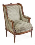 A French walnut wing armchair, in Louis XVI style, late 19th century, the shaped rectangular back