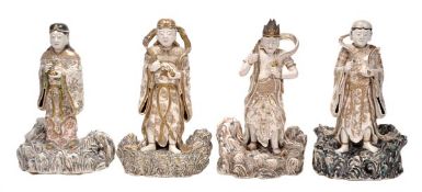 A set of four Satsuma style pottery figures of celestial guardians, each stands on an elaborately