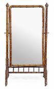 A stained beech simulated bamboo cheval mirror, circa 1870, the arched rectangular plate with a