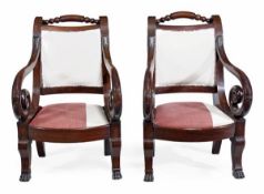 A pair of Continental mahogany armchairs, 19th century, each with an over scrolling back with