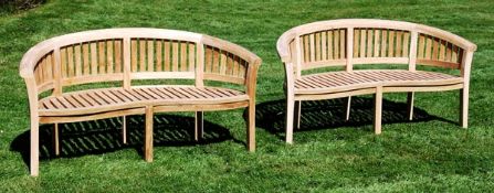 A pair of teak garden benches, of recent manufacture, each with arched backrest with vertical