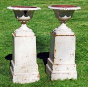 A pair of Victorian painted cast iron garden urns and pedestals, last quarter 19th century, the