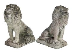 A pair of reconstituted stone garden models of seated lions, 20th century, cast opposing, on