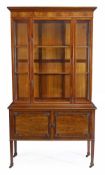A mahogany cabinet on stand, circa 1900, the moulded cornice above a glass panelled upper section