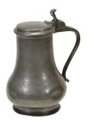 A wriggle worked pewter lidded flaggon, early 18th century, of baluster form, the lid and body