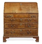 A George II walnut bureau, circa 1740 and later, the rectangular fall opening to small drawers and p