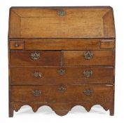 A George III oak fall front bureau, circa 1780, the fall opening to an arrangement of drawers,