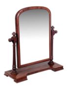 A William IV mahogany dressing mirror, circa 1835, the arched plate and framed supported by a pair o