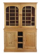 A pine cabinet, circa 1880 and later, the moulded cornice above a pair of glass panelled doors