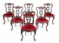 A set of six Victorian chairs, circa 1870, each with scroll carved shaped backs, with padded seats o