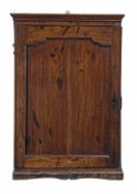 A George III oak hanging cupboard, circa 1780, the moulded cornice above a panelled cupboard door