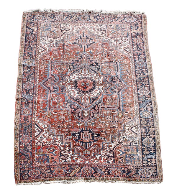 A Heriz carpet, decorated throughout with foliate motifs, the madder field centred by a cream