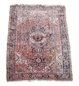 A Heriz carpet, decorated throughout with foliate motifs, the madder field centred by a cream