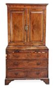 A walnut and featherbanded cabinet on chest, circa 1740 and later, the moulded cornice above a