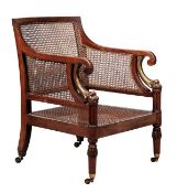 A mahogany and parcel gilt library bergere armchair, 19th century, the shaped rectangular back