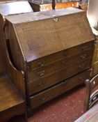 A George III oak fall front bureau with a fitted interior and four long drawers on bracket feet