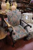 A Victorian mahogany and upholstered armchair with outscrolled arms on carved cabriole legs
