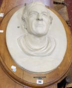An oval relief plaster bust of Sydney Smirke R.A, with a moulded oak mount 52 x 41, (A/F)