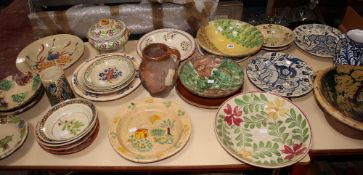 A large assortment of French and other provincial pottery items including plates, bowls, jugs, etc.