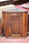 A 19th century elm small hanging corner cupboard