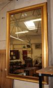 A modern rectangular gilt decorated wall mirror 120 x 78cm and oval mirror