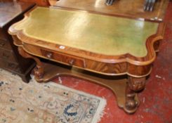 A Victorian mahogany serpentine fronted writing table with a frieze on carved legs and a shaped