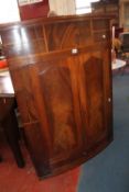 An early 19th century mahogany bowfront hanging corner cupboard 118cm high, 89cm wide  Best Bid