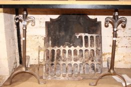 A cast iron fire back, grate and pair of steel andirons with fleur de lys detail