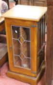A revolving display cabinet with linen fold panels 91cm high, 41cm wide