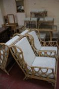 A large quantity of caned garden furniture to include a table and chairs, stools and coffee tables
