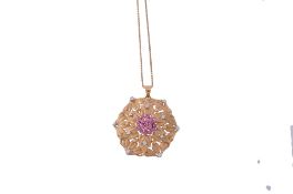 A ruby and diamond flower head pendant, the circular pierced pendant with... A ruby and diamond