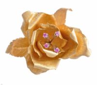 A ruby and gold coloured rose brooch, with engraved leaves A ruby and gold coloured rose brooch,
