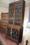 An early 20th Century oak and stained glass bookcase enclosing shelves 215cm high, 101cm wide