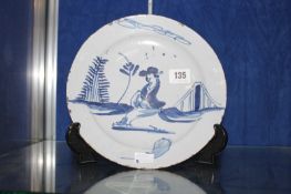 An English Delft blue and white plate, possibly Bristol, decorated with a Chinese figure within a