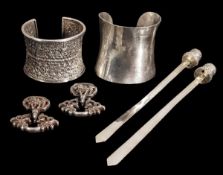 A group of silver objects, 19th century, comprising two cuffs, one plain, the other decorated with i