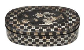 A Chinese lacquer box and cover of oval form, decorated in inlaid mother-of-pearl on a black