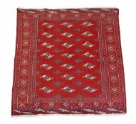 A Bokhara carpet, the madder field decorated with burnt orange and ivory lozenge medallions