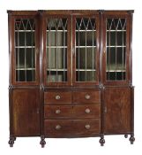 A George IV mahogany breakfront library bookcase, circa 1825, the upper section with astragal