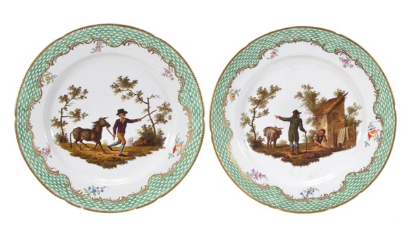 A pair of Coalport porcelain fable plates, each painted with scenes of a man and an ass, within a