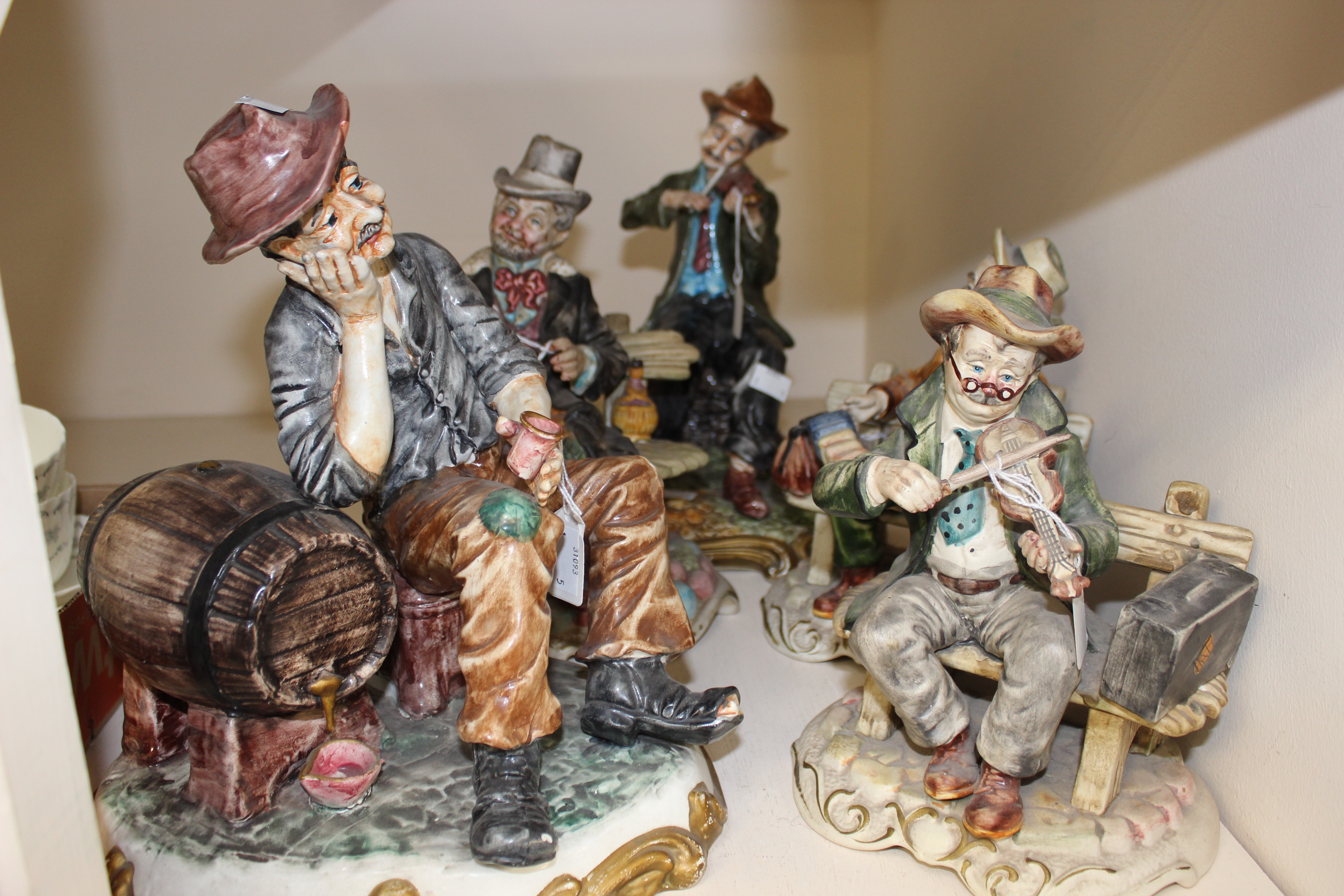 A collection of five Capodimonte figure groups, including man playing accordion, man playing violin,