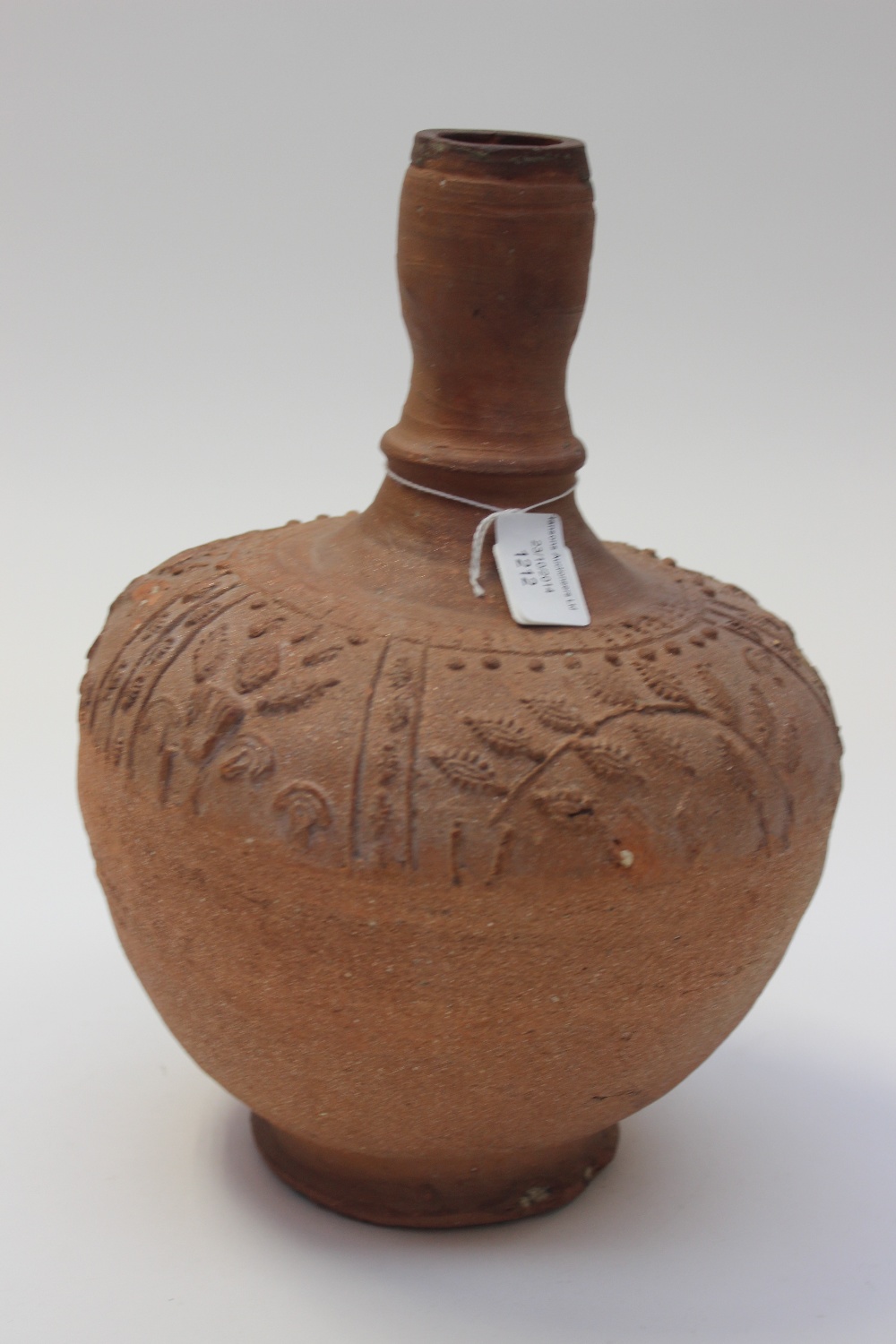 A terracotta vase of necked ovoid form with impressed relief moulded band of floral design, probably