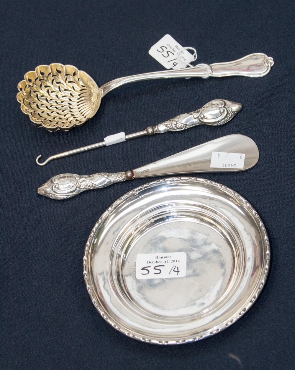 A continental silver sifter spoon with gilt bowl, together with a silver handled button hook and