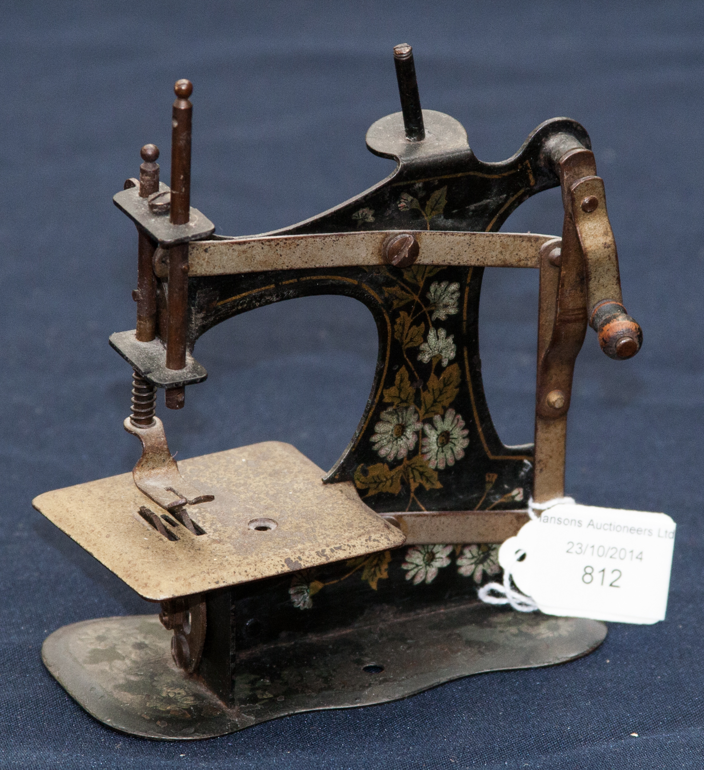 A mid 20th Century miniature toy sewing machine, with floral decoration